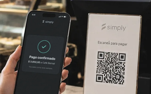 En el mostrador de un café, un cartel con el QR de Simply y un teléfono que muestra el pago confirmado.